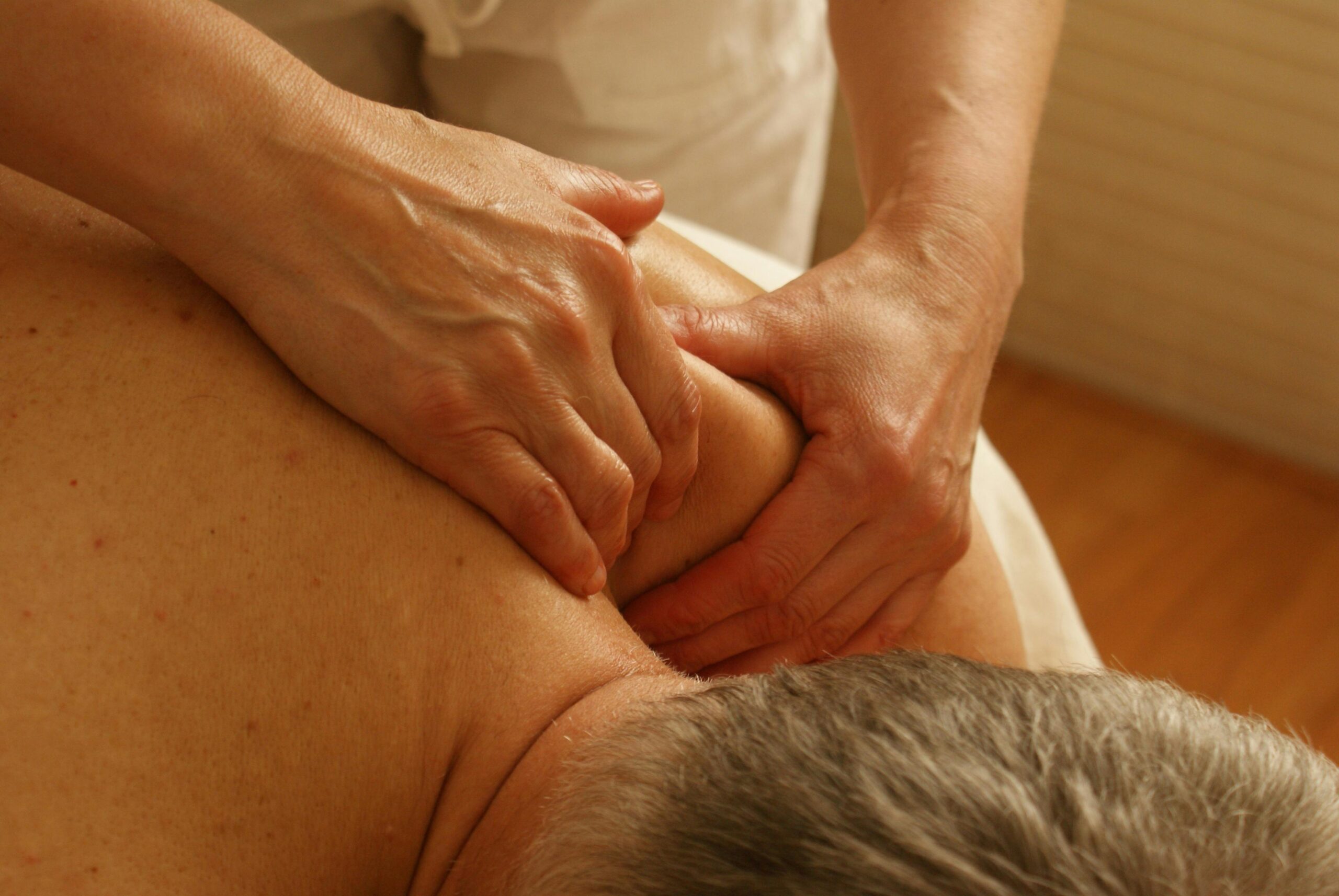 A client receives a shoulder massage to relieve pain at a Vicars Giving Clinic.